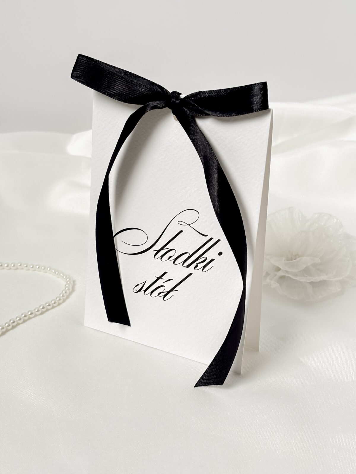 Karta informacyjna z czarną kokardą i napisem „Słodki stół”