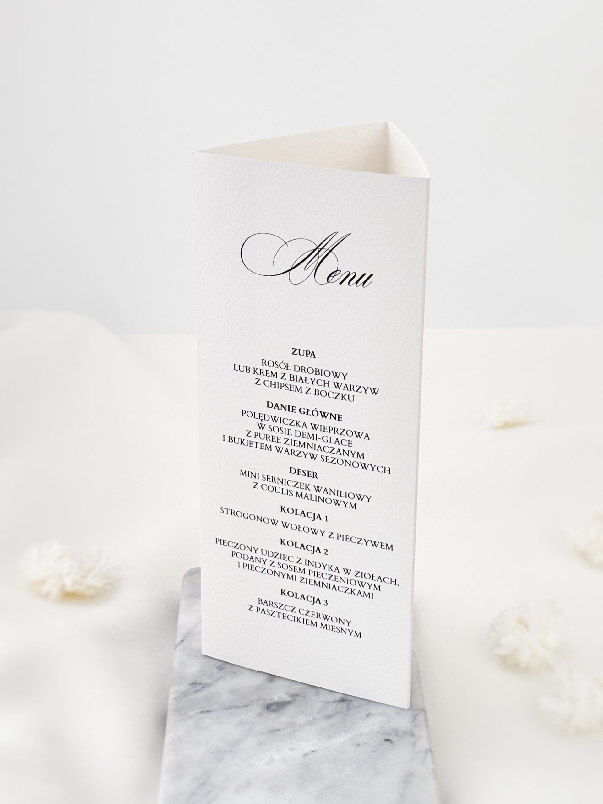 Stojące menu weselne w delikatnej aranżacji z białymi kwiatami