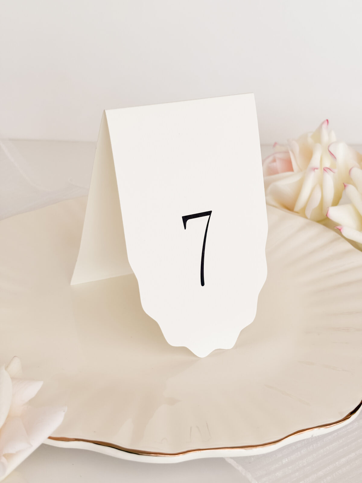 Minimalistyczny numer stołu, biała karta z dekoracyjnym dołem, minimalizm i czytelność