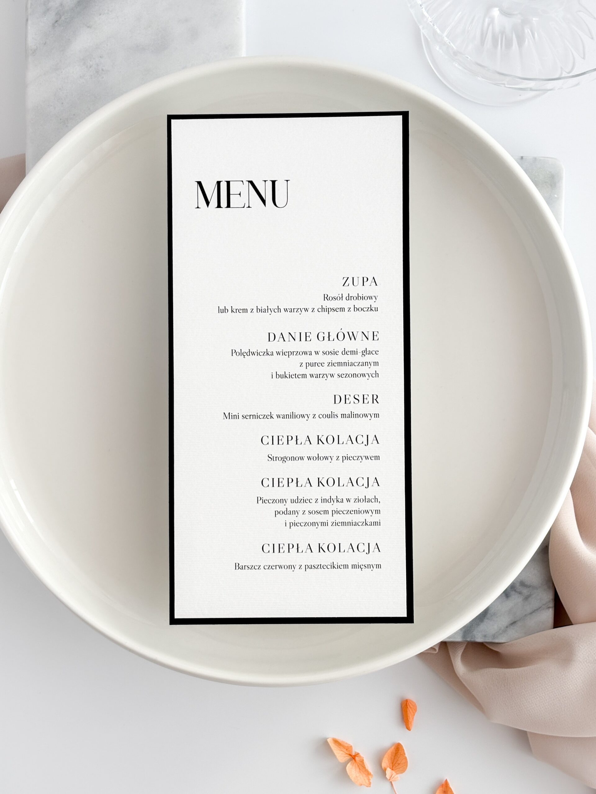 czarno-białe menu weselne ułożone na talerzu