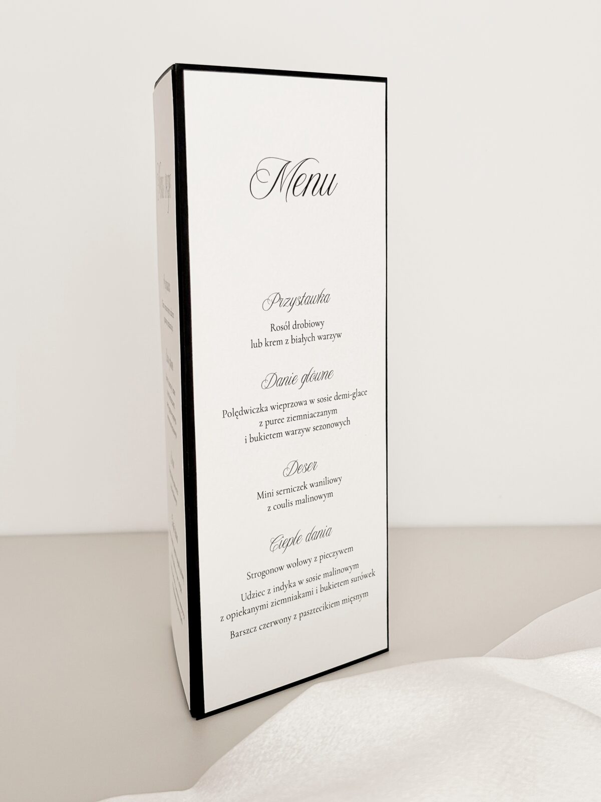 czarno-białe menu weselne trójkątne ustawione na stole
